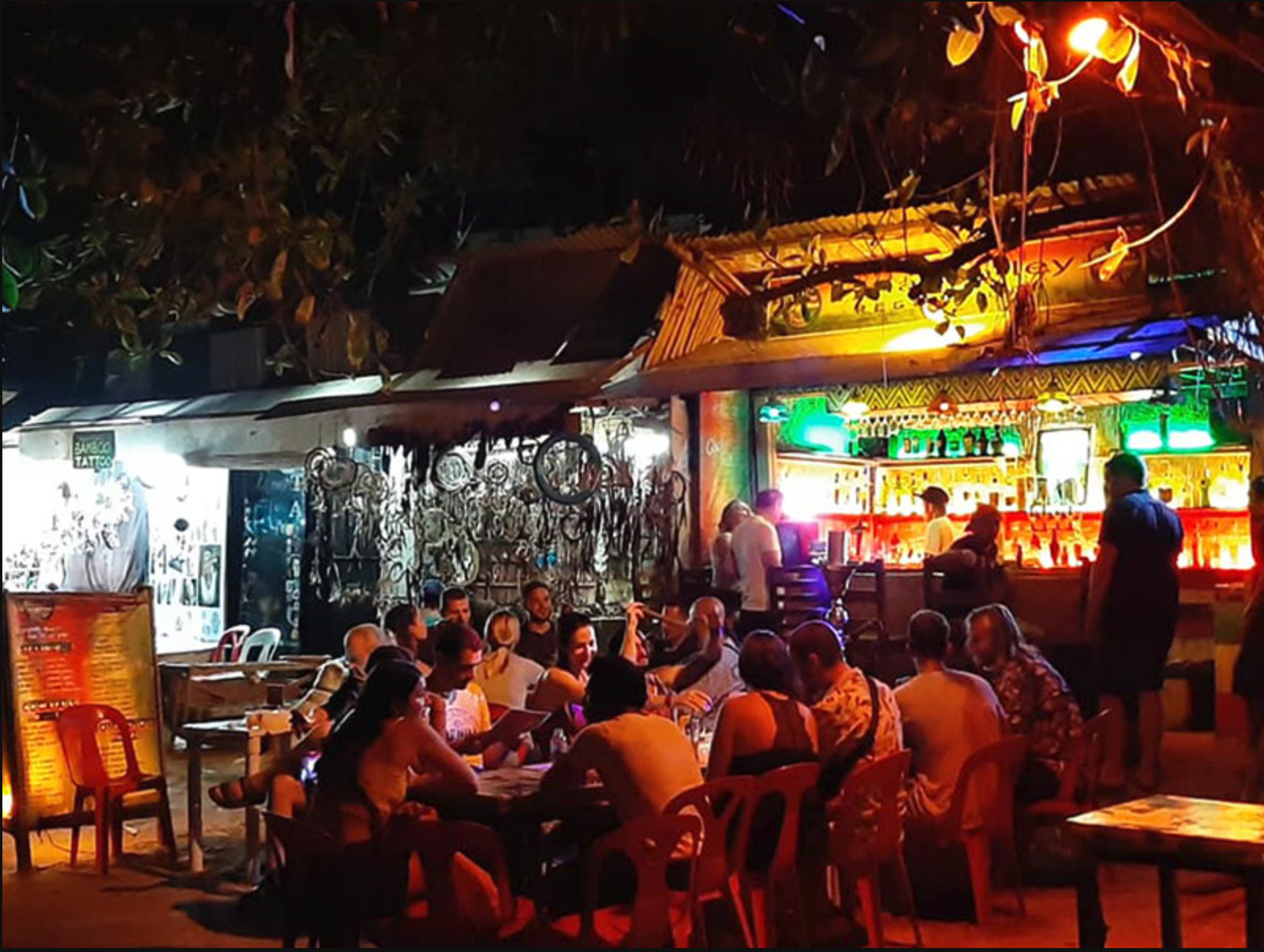 Neon sign and lively bar scene on Alona Beach, Panglao.